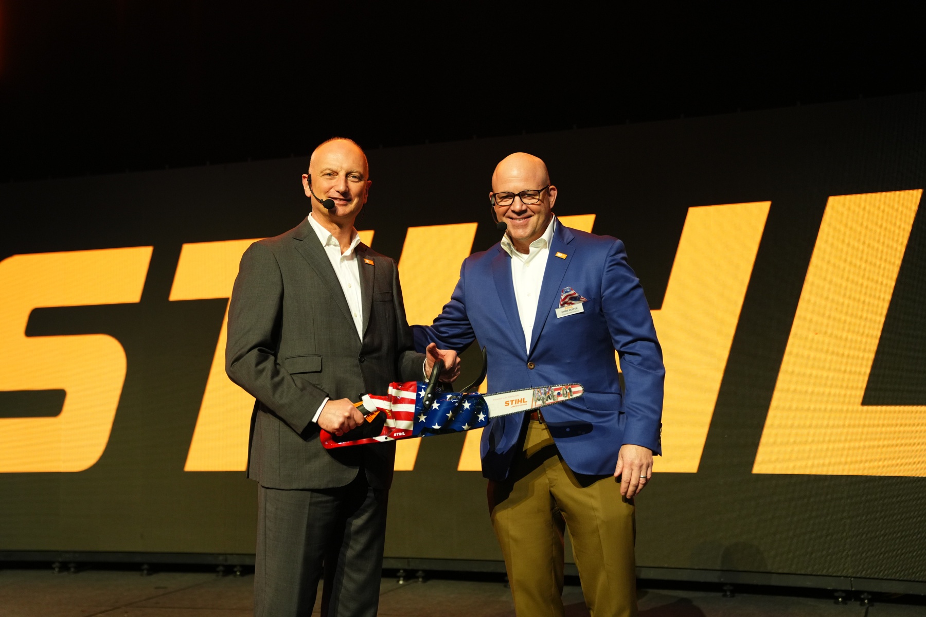 Dr. Nikolas Stihl (links) en Chris Keffer, algemeen directeur van STIHL Inc. in de VS, overhandigen een jubileumzaag met een Amerikaanse vlag.