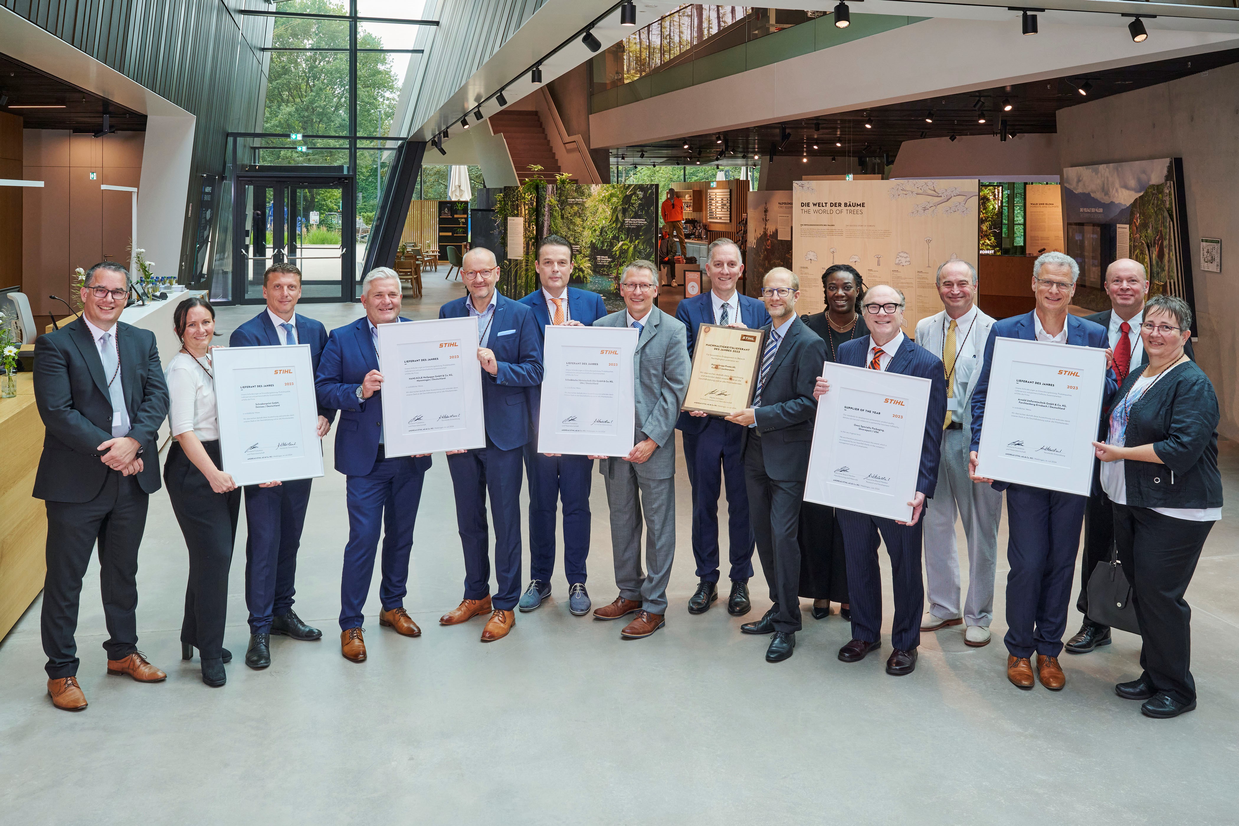 Martin Schwarz, lid van de Raad van Bestuur van STIHL voor Productie en Materialen (links), en Marc Moser, Vice President Purchasing (rechts achteraan), met de bekroonde leveranciers van de STIHL Brand World.